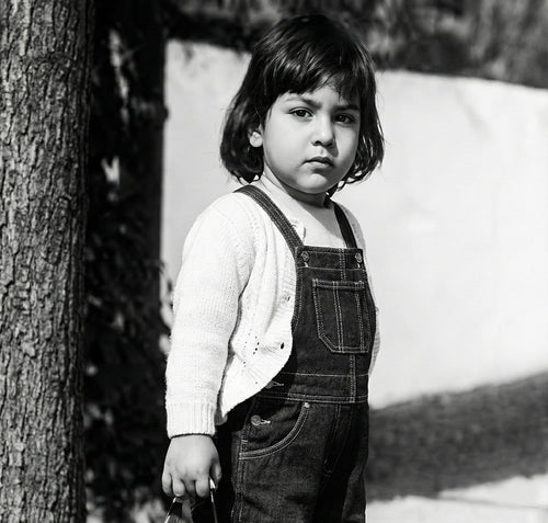Black and white childhood portrait of young Shawn Rae standing outdoors