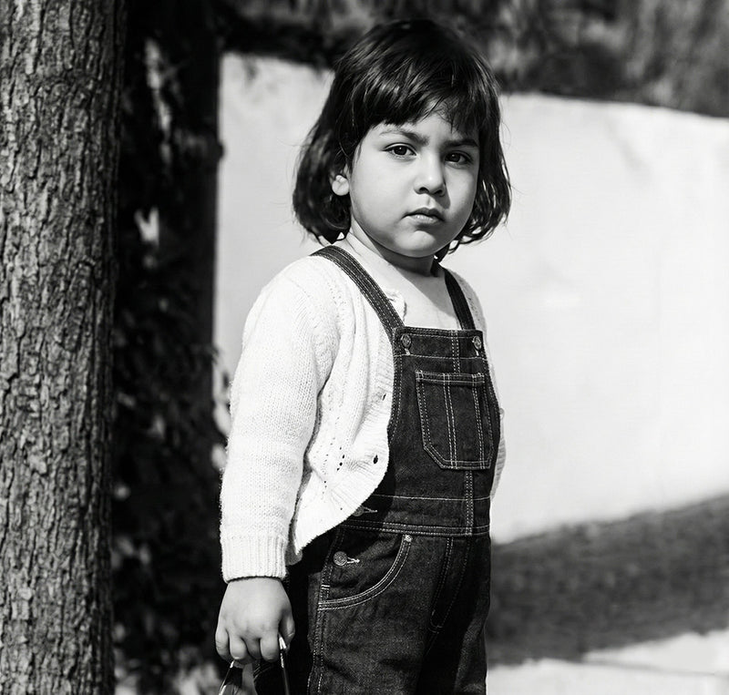Black and white childhood portrait of young Shawn Rae standing outdoors