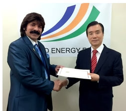 Shawn Rae shaking hands and holding a document with a delegate at World Energy Forum